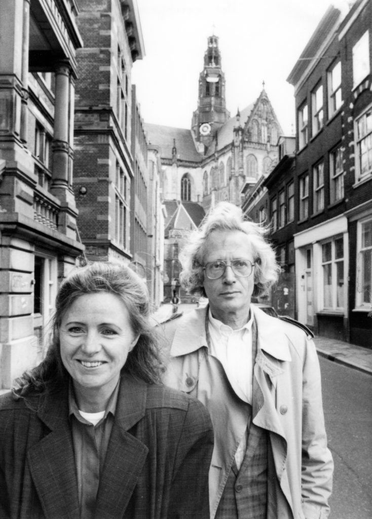 Els Hendrikse en Piet Kee wandelend in de Jansstraat, Haarlem. In de achterfrond de Grote of St.-Bavokerk waar Piet Keer stadsorganist was.